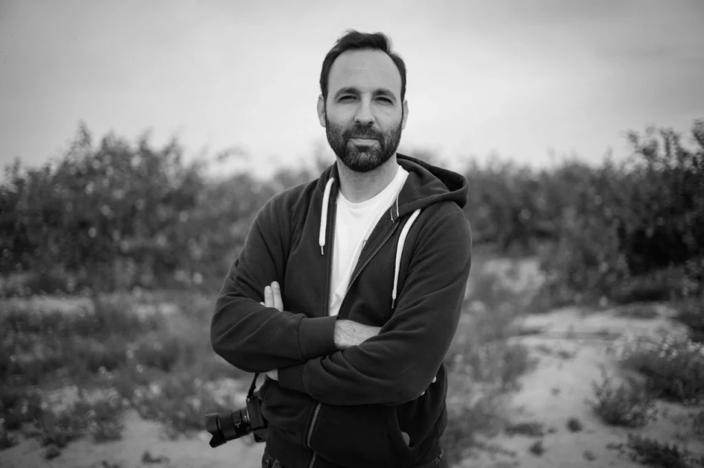 Black and white portrait of a photographer with a camera at an outdoor location in southeast Spain, near Mar Menor